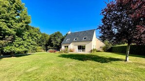 A two-story house with a sloped roof, a front porch, and a well-maintained lawn. - Charming villa - beaches 5 minutes away (Carolles)