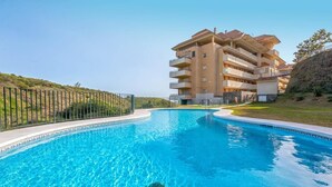 Una piscina con un edificio al fondo.