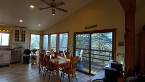 Une cuisine spacieuse avec un coin repas, de grandes fenêtres et un ventilateur de plafond.
