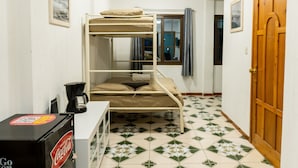 A bunk bed room with a window, a door, and a refrigerator. - Atitlans House  (Panajachel)