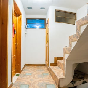 Staircase leads to a spacious area with a window and geometric tile steps.