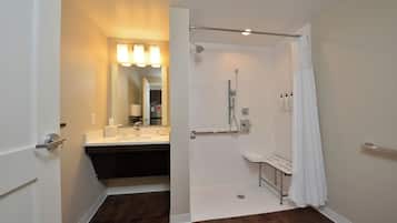 A modern bathroom with a walk-in shower, a vanity with a mirror, and a toilet.