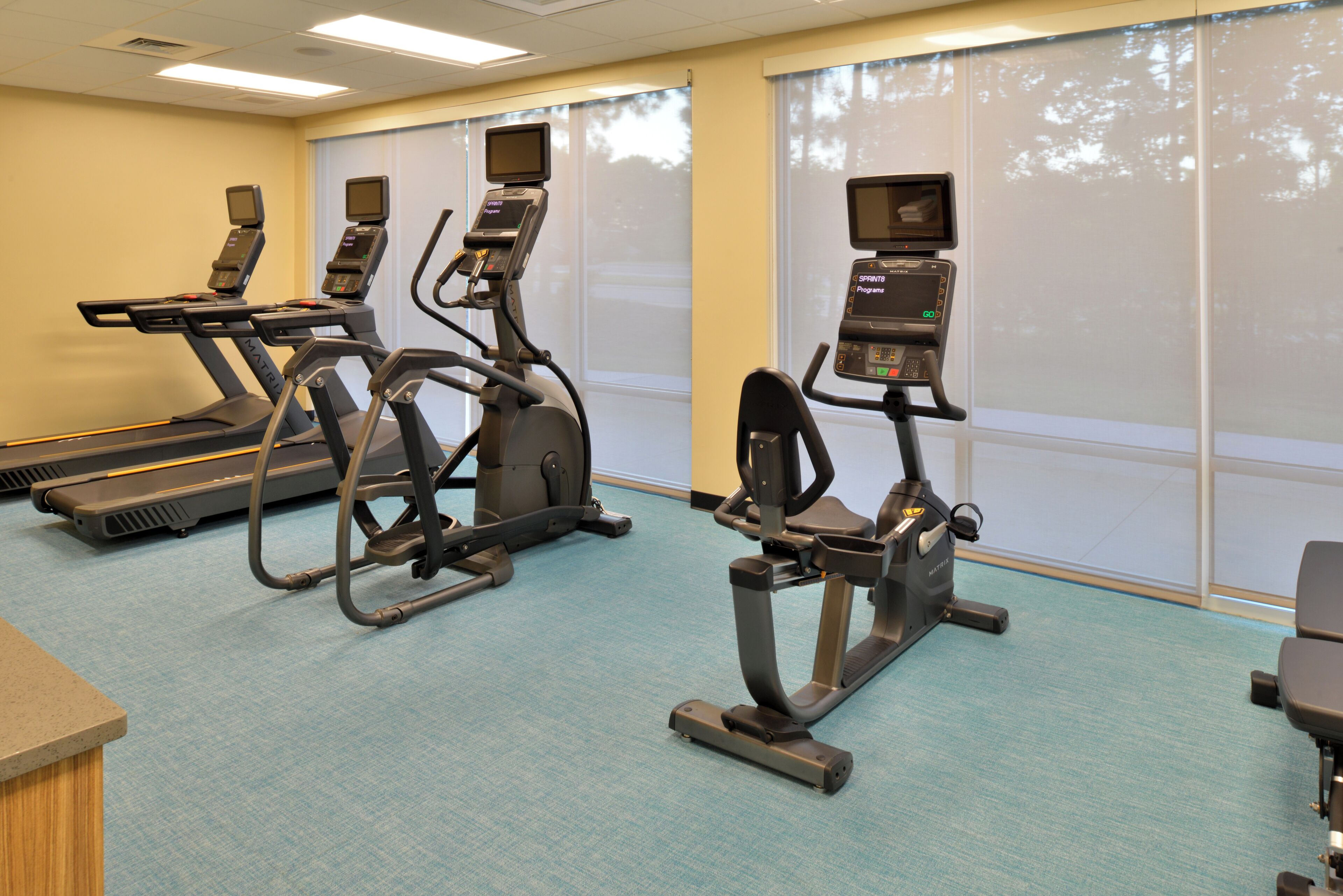 A fitness center with treadmills, ellipticals, and stationary bikes.