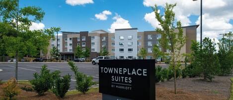 A sign for Towneplace Suites by Marriott with a view of the hotel buildings in the background.