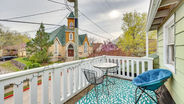 A balcony with a white railing, a table, and two chairs. - Eureka Springs Vacation Rental < Half-Mi to Dtwn! (Eureka Springs)