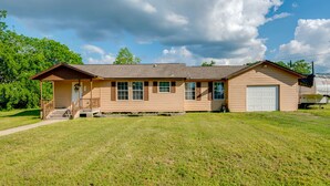 A single-story house with a front porch, a garage, and a well-maintained lawn. - Kayak, Fish & Golf - Charming Victoria Home! (Victoria)