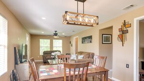 A dining area with a wooden table and chairs, a ceiling fan, and a chandelier. - Kayak, Fish & Golf - Charming Victoria Home! (Victoria)