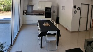 A modern kitchen with white cabinets, a dining table with chairs, and a refrigerator. - Escape and comfort 8-bed house with swimming pool (Val de Chaise)
