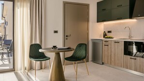 Une cuisine moderne avec un coin repas, comprenant une table ronde, deux chaises et une porte.