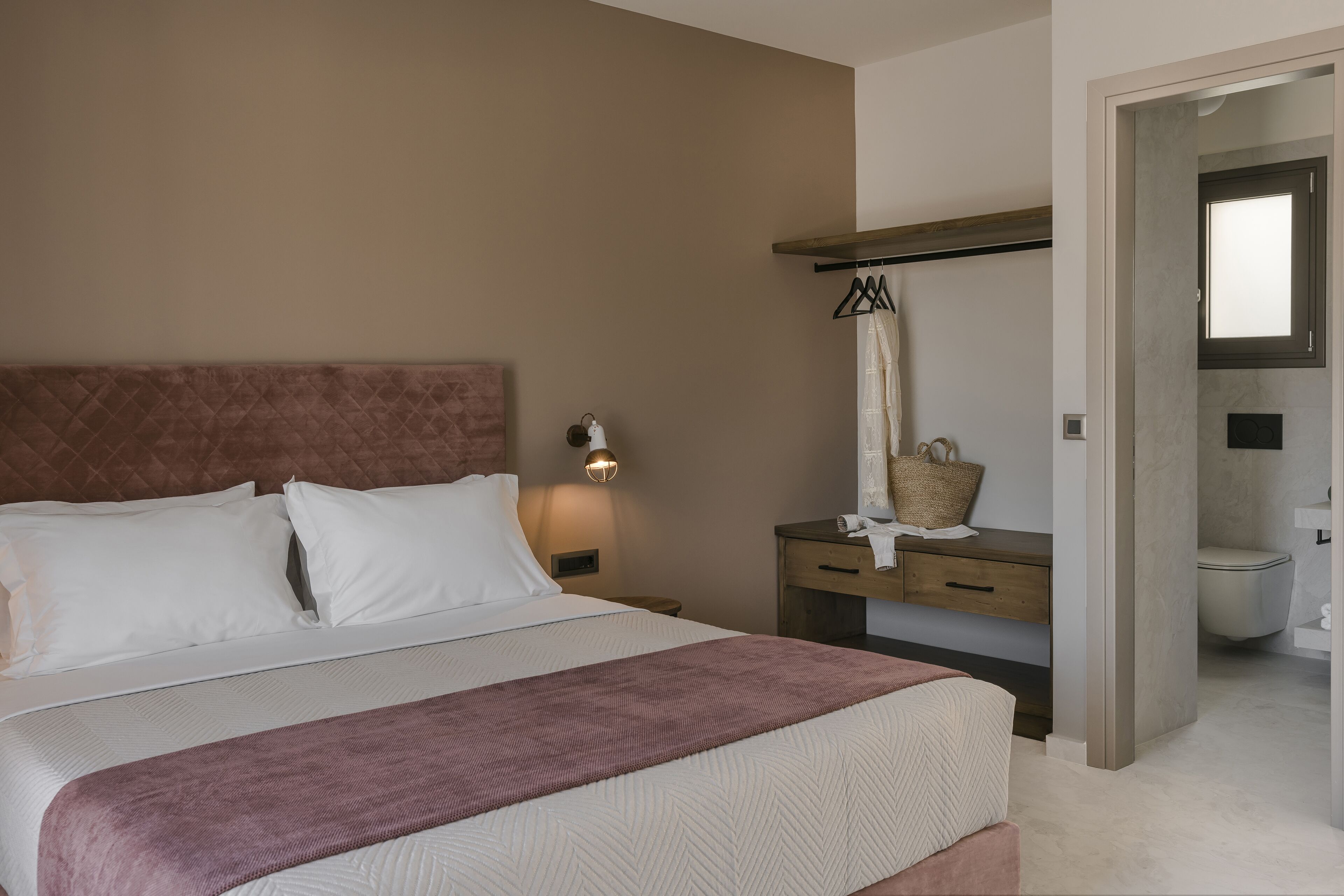 Un dormitorio con cama, mesita de noche y velador.