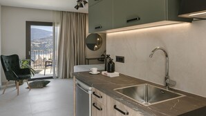 Une cuisine moderne dotée d’une grande fenêtre, d’un coin repas avec une chaise et d’une vue sur l’extérieur.