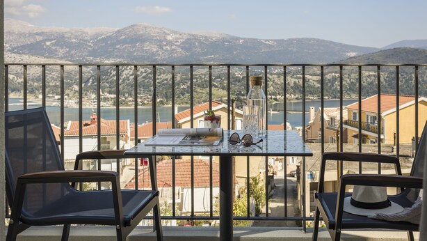 Un balcon avec une table, des chaises et une vue sur un paysage montagneux.