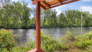 Vista sul fiume con struttura in legno a pergola.