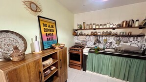 Una cocina con un armario de madera, una estufa y un salpicadero de azulejos.