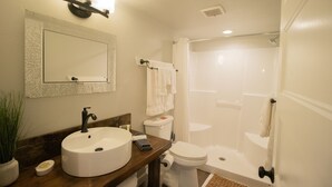 Un baño con lavamanos, inodoro y ducha.