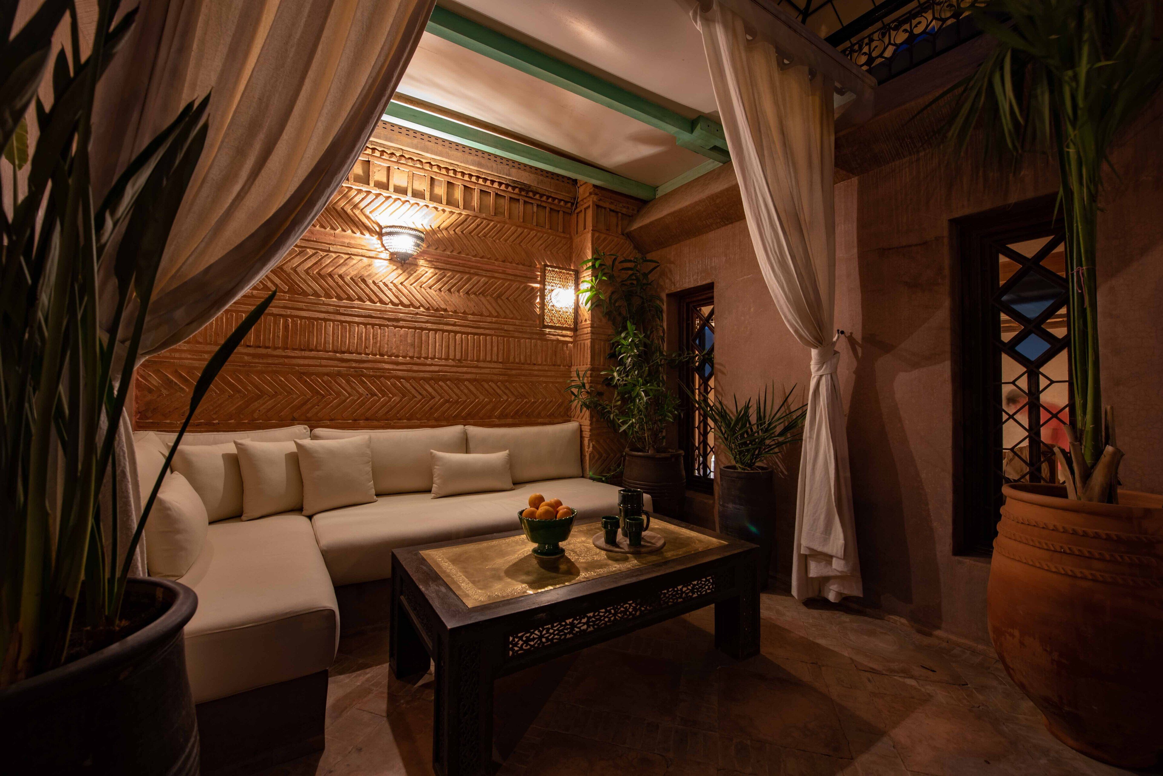A cozy lounge area with a sofa, a coffee table with decorative items, and potted plants.