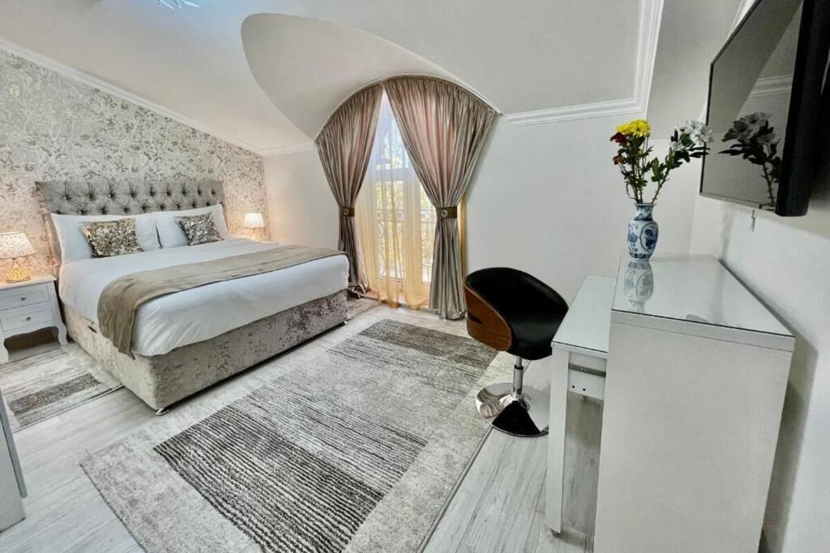 Een moderne slaapkamer met een groot bed, een bureau en een stoel.