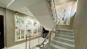 Un escalier avec des rampes en métal et une fresque murale.
