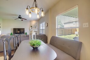 Relax in this stylish living room with a curved dining table, comfortable sofa, and flat-screen TV.