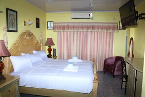 Une chambre d’hôtel équipée d’un grand lit, d’un bureau, d’une chaise, d’une télévision et d’un appareil de climatisation.