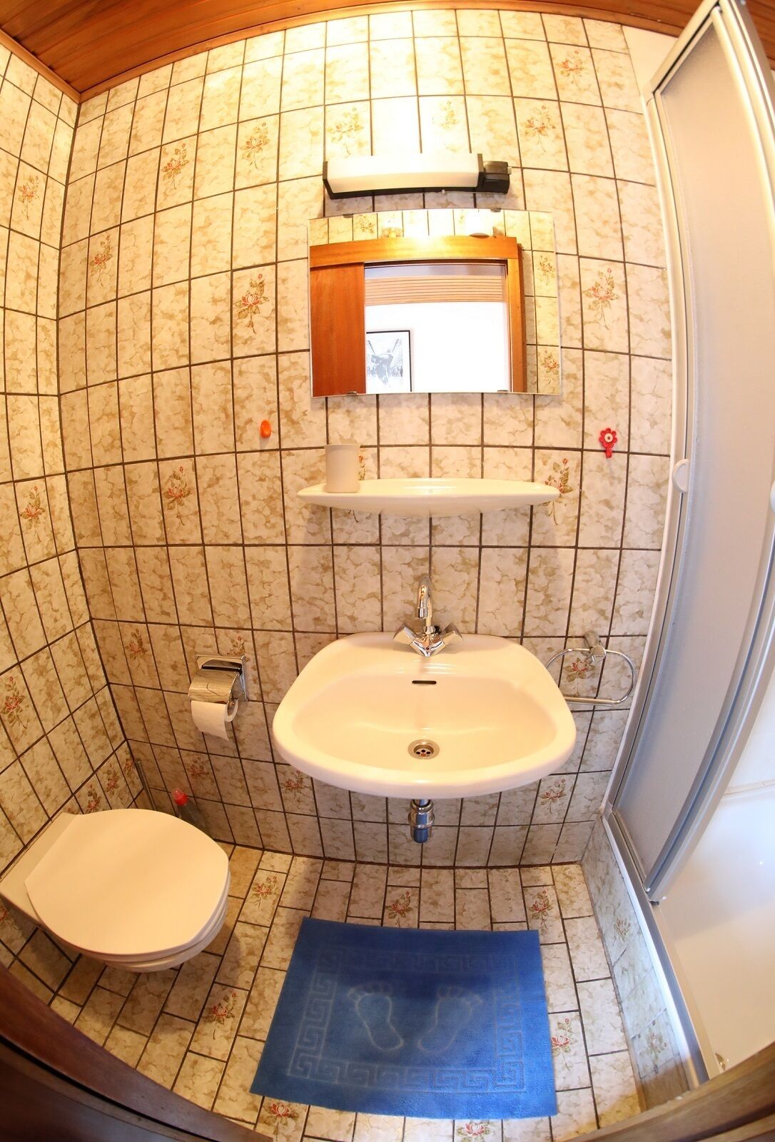 Un baño pequeño con inodoro, lavamanos y ducha.