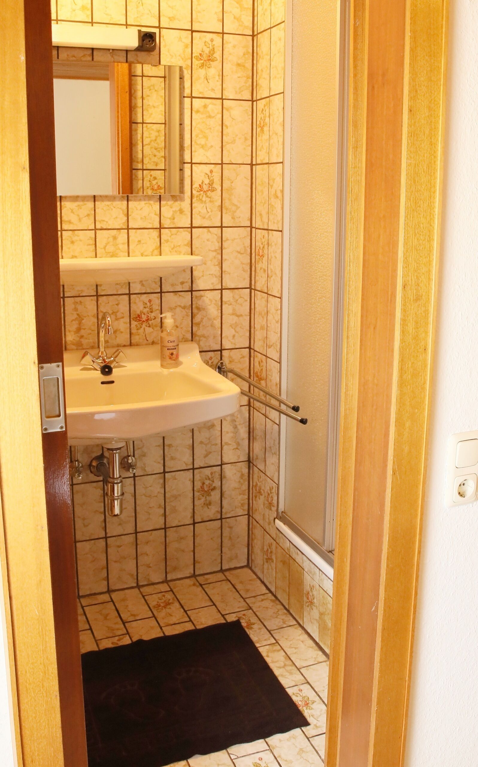 Ein Badezimmer mit Waschbecken, Spiegel und Dusche.