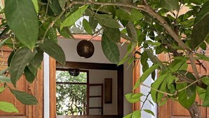 An entrance with a wooden door, a small table, and a patterned sofa. - Private Moroccan Riad • Rooftop Dinners & Pool • Luxury Experience (Marrakesh)
