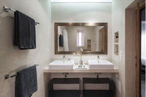 A bathroom with two sinks, a large mirror, and a towel rack.