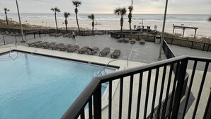 A pool area with lounge chairs and a view of the beach. - Complimentary Beach Service with 2 chairs and umbrella (Panama City Beach)