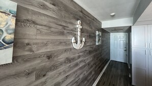 A hallway with wooden paneling and a large anchor decoration. - Complimentary Beach Service with 2 chairs and umbrella (Panama City Beach)