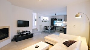 A modern living room with a white sofa, a flat-screen TV, and a fireplace. - Villa Gea - Three Bedroom with Swimming Pool (Barban)