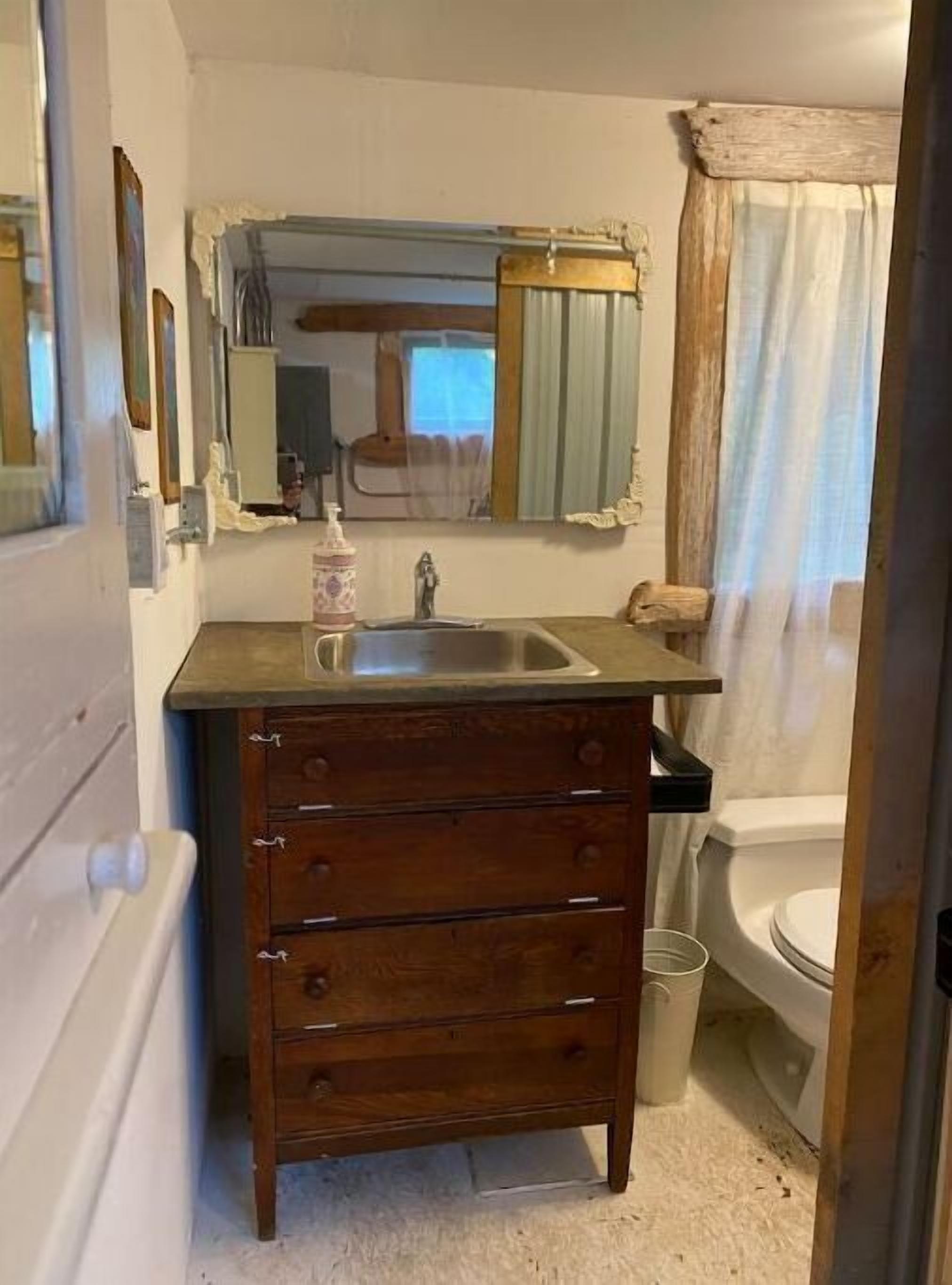 Une petite salle de bain avec un meuble-lavabo en bois, un lavabo et des toilettes.