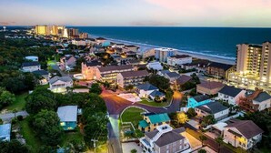 A coastal town with residential buildings, a beach, and a large hotel complex. - 3BR Boho Design | Fire Pit | Steps to Beach (North Myrtle Beach)