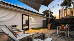A patio with outdoor furniture, a fire pit, and a small table with a plant.