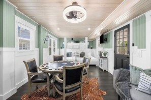 A dining area with a round table, chairs, and a ceiling fan.