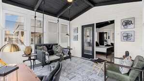 Un salon moderne avec un canapé, un fauteuil, une lampe et des œuvres d’art accrochées aux murs.