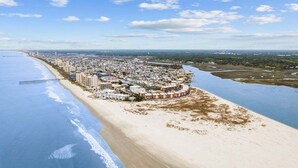 A coastal cityscape with a beach, a pier, and a dense cluster of buildings. - Hem's Hideout | 5BR Tropical Oasis w/ Heated Pool (North Myrtle Beach)