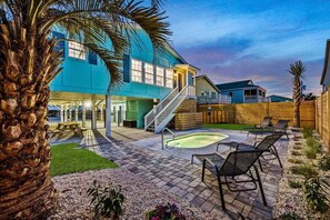 Ein Garten mit Swimmingpool, Liegestühlen und einer Holzterrasse.