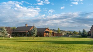 A large, open grassy area with several wooden cabins and a clear blue sky. - Utah's Best-Kept Secret: Secluded and Serene Cabin Getaway, Uta's Best-Kept Secret: Secluded and Ser (Garfield County)