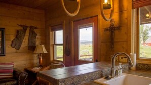 Una cocina rústica con mostrador de piedra, un fregadero y una ventana con vistas al exterior.