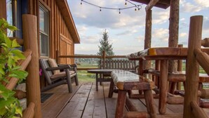 Una terraza de madera con un sofá y una mesa, rodeada de barandillas de madera.