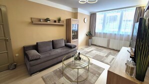 Un salon avec un canapé, une table basse, un meuble et une fenêtre avec des rideaux.