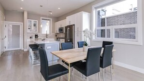 A modern kitchen with white cabinets, stainless steel appliances, and a central island. - 2 Newly Built Luxury Condos with Private Roofdeck! (Chicago)