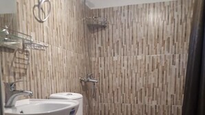 A modern bathroom with a wooden wall design, a shower, and two toilets. - Lileo (Akhmeta)
