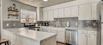 Dog-friendly water view condo with inviting porch, AC, W/D, & modern charm