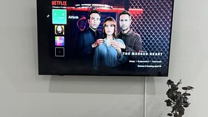 Een flatscreen-tv aan een muur met een Netflix-interface, waarbij de serie 'The Married Heart' wordt benadrukt.