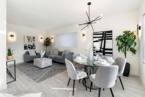 Relax in this stylish living room with a sofa, coffee table, and dining area.