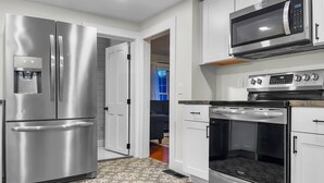 A modern kitchen with stainless steel appliances, including a refrigerator, microwave, and oven. - Rivers Edge (Freedom)