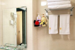 A bathroom with a mirror, a hairdryer, a shelf with toiletries, and towels. - Lian'Jia Apartment Hotel (Shenzhen Dachong Xincheng Huayuan) (Shenzhen)