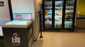 Une vitrine réfrigérée avec une enseigne indiquant « LOS LOS Servitas » et un écran numérique au-dessus.